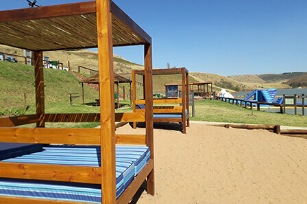Day beds set on beach sand around a dam