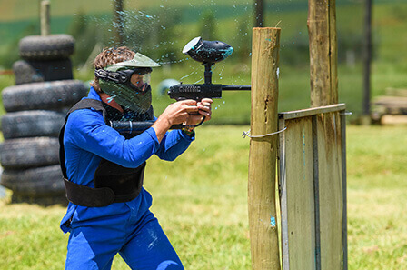 The moment a person's paintball gun is hit by a paintball, spraying paint over his mask