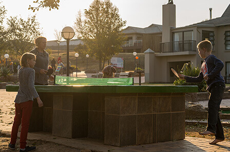 A group of children playing outdoor table tennis